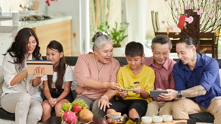 Asian family in the living room with smart devices